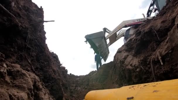 Escavatore con grande secchio seppellisce fossa profonda con conduttura — Video Stock