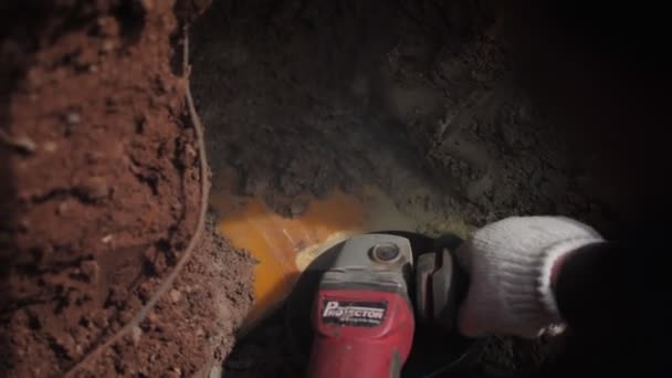 Arbetaren tar bort höljet från röret och grävmaskinen slår på backen — Stockvideo