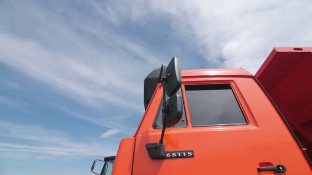 Movimiento alrededor de camión volquete rojo con logo complejo industrial — Vídeos de Stock