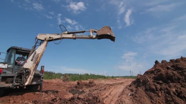 Bagr vykopává díru s vědrem na staveništi — Stock video