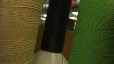 Raflardaki farklı ipliklerle bobinler arasında hareket