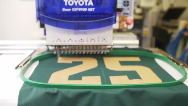 Вышивальная машина с логотипом хоккейной команды в швейной мастерской — стоковое видео