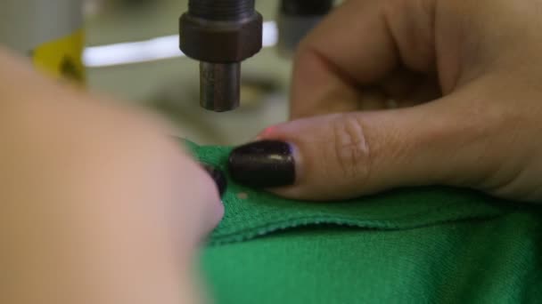 Seamstress installe des oeillets métalliques dans l'uniforme de hockey vert — Video