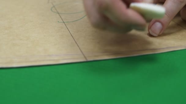 Pracownik rysuje część na zielonym materiale z kredą w warsztacie — Wideo stockowe
