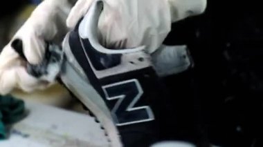 Eldivenli kişi fırçalar, marka spor ayakkabısı ve sabun tozu