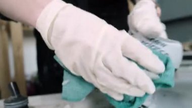 İşçi yakın planda spor ayakkabısından bez parçasıyla köpük çıkarıyor