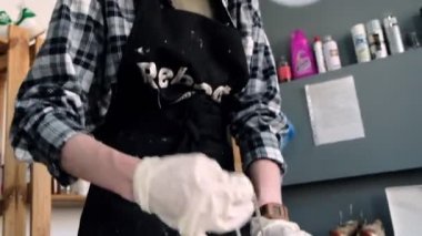 Kadın işçi dükkandaki masada ayakkabıdan dantel çıkartıyor.