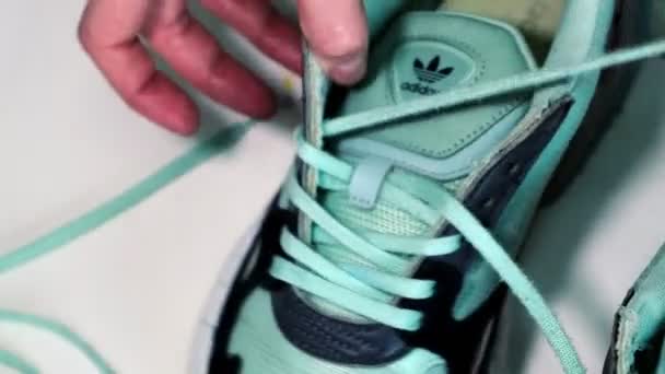 Zapatilla verde claro de los cordones del trabajador en la mesa en taller — Vídeos de Stock