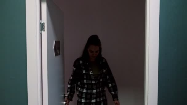 Žena odejde z místnosti zavírající dveře se jmenovkou Reboot