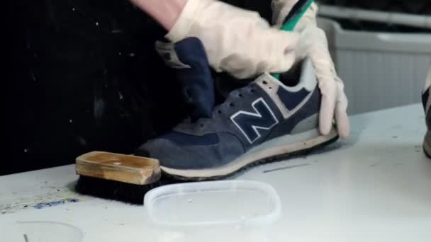 Женщина снимает кровати и чистит подошвы от кроссовок — стоковое видео