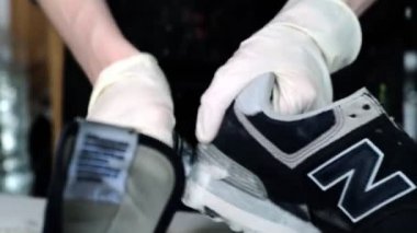 Tamirhanede sabunla ayakkabının tekini temizleyen kişi.