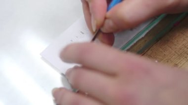 Kadın dikiş dükkanındaki masada üzerinde harflerle çalışıyor.