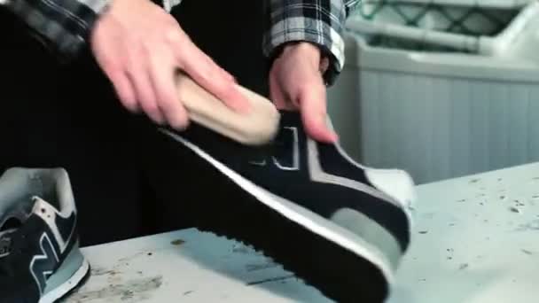 Femme nettoie sneaker en cuir noir avec brosse à table — Video