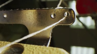 Dikiş makinesinin metal bölümündeki delikler boyunca ilerler