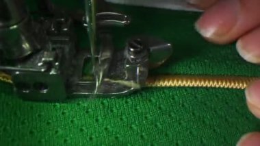 Terzi atölyede hokey üniformasına altın dantel dikiyor.