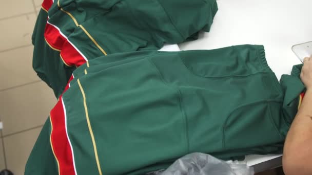 Pilha de calças uniformes de hóquei verde acabados na mesa — Vídeo de Stock