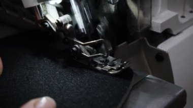 Kadın işçi siyah köpük kauçuk detaylarını makineyle dikiyor