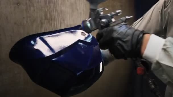 Працівник малює маску синього кольору повітряною щіткою в магазині — стокове відео