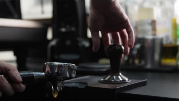 Hombre utiliza manipulación para presionar café molido fresco en la encimera — Vídeos de Stock