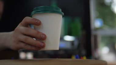 Barista boş bardakla taze kahveyi masaya koyar.