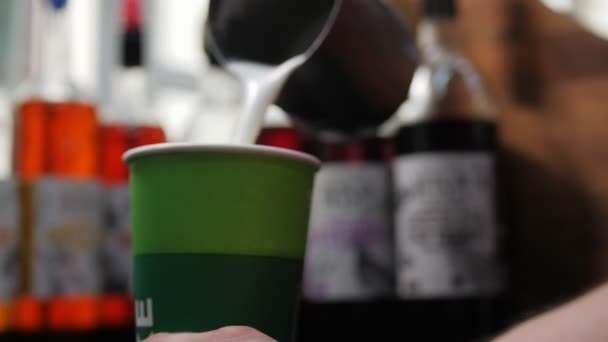 Barista verse de la crème fouettée dans une tasse verte avec du café frais — Video