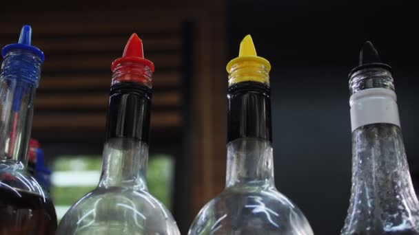 Movimiento a lo largo de la fila de botellas de jarabes con dosificadores en la cafetería — Vídeo de stock