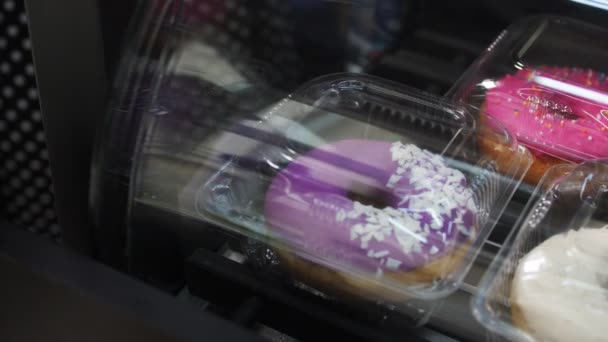 Vitrine met donuts en broodjes verpakt in containers — Stockvideo