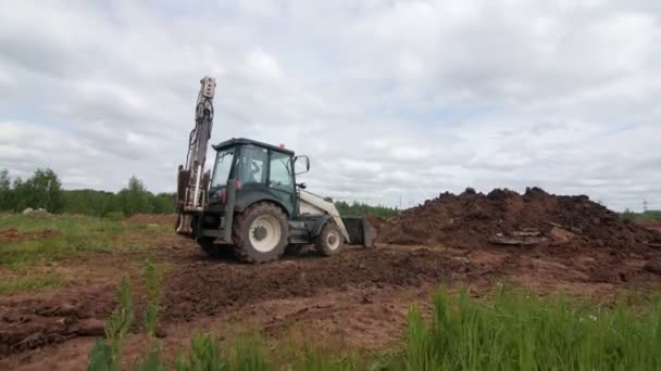 Buldozer stojí v blízkosti pozemní hromádky poskytnout potrubí práce — Stock video