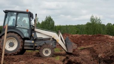 Buldozer, sarı boruyla sipere toprak dökmeye gidiyor.