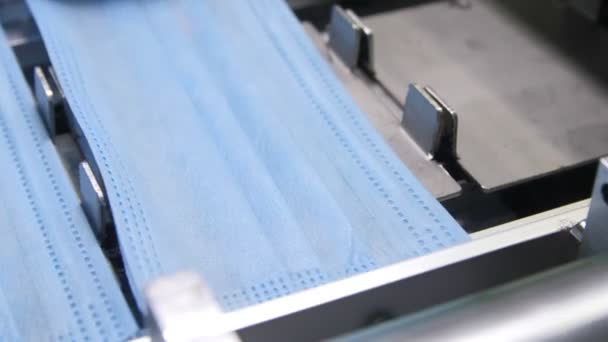 Linia produkcyjna transportuje arkusze niebieskiego materiału włókienniczego do masek — Wideo stockowe