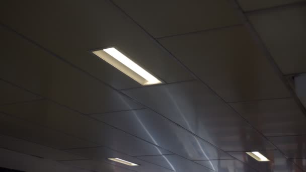 Cienie spacerujących ludzi poruszają się po suficie z lampami LED — Wideo stockowe