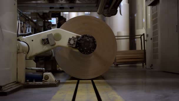 İşçi ambalaj kağıdı rulosu ile çalışan makineyi kontrol eder — Stok video