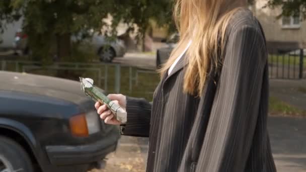 Jonge vrouw komt naar prullenbak te gooien gebruikte pack op straat — Stockvideo