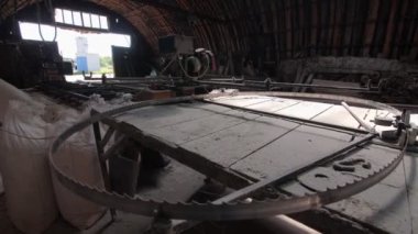 Vintage atölyesindeki tozlu tezgahta büyük yuvarlak metal testeresi.