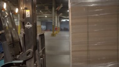 Forklift yükleyicileri depo boyunca katlanmış kutular
