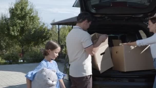 Keluarga dengan anak kecil beban barang-barang ke bagasi mobil — Stok Video