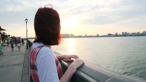 Femme aime coucher de soleil appuyé sur la rampe sur le remblai de la rivière — Video