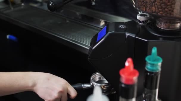 Barista fyller portafilter med malet kaffe från maskinen — Stockvideo