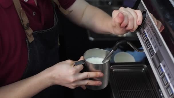 Empregado chicotes de leite com máquina para preparar bebidas no café — Vídeo de Stock