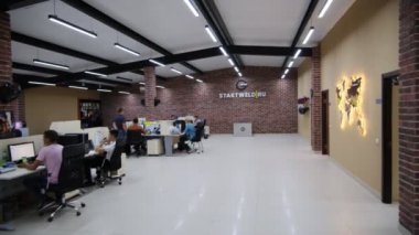 Ofisteki insanlar dünya haritası ve kaynakçı maskeleriyle çalışıyorlar.