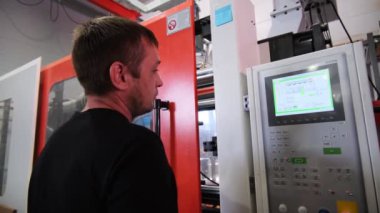İşçi dükkandaki makine aracının kontrol panelinde tuşlara basar