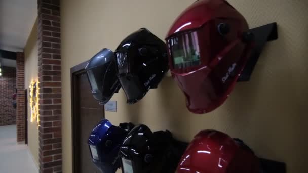 Schweißermasken hängen in großem Firmenbüro mit Mitarbeitern — Stockvideo