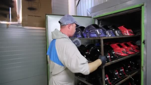 Empregado coloca rack com máscaras de soldador de proteção no gabinete — Vídeo de Stock