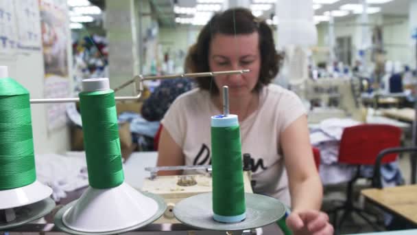 Mujer controla máquina de coser con bobinas de hilos verdes — Vídeo de stock