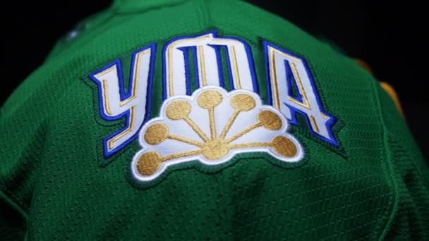 Uniforme de hockey verde con logo y palabra Ufa en taller oscuro — Vídeo de stock