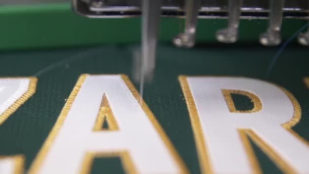 Altın iplikli yeşil kumaşa işlemeli makine harfleri — Stok video