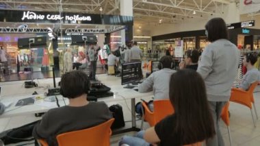 Ekipmanlı film ekibi masa başında moda gösterisinde oturuyor.