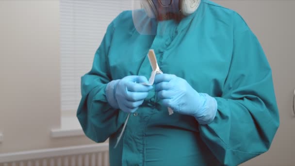 Медсестра в защитном костюме открывает лопатку в больничном кабинете — стоковое видео
