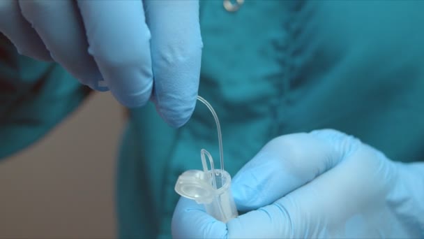 Медсестра кладе тампон із зразком мазків пацієнта в контейнер — стокове відео