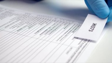 Eldivenli hemşire tıbbi sigorta poliçesine yapıştırıcı yapıştırıyor.